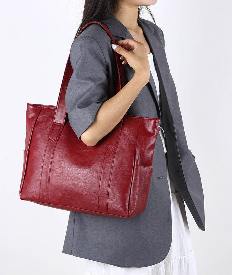Large deep red handbag with spacious chamber and long strap