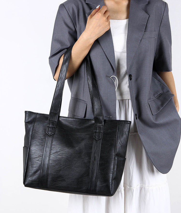 Large black handbag with spacious chamber and long strap